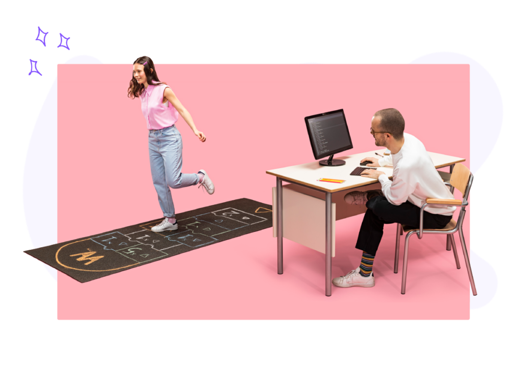 Una studentessa che gioca a Campana allegramente mentre un docente la guarda incoraggiante dietro una scrivania e scrive al computer